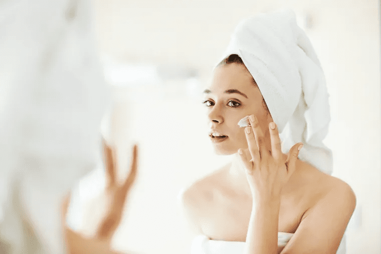 Girl applying cream to face